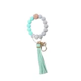 Llavero con pulsera de cuentas de silicona en tonos verde agua y gris, con una cuenta de madera natural y borla de flecos verde agua.