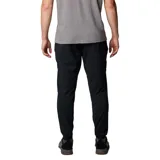 Pantalón de trekking negro con corte tapered, tejido resistente al agua y a las manchas, cintura elástica, bolsillos delanteros, bolsillo de seguridad, dobladillo elástico, entrepierna reforzada, pierna acampanada y bolsillo trasero con botón de presión.