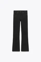 Pantalón de jean negro de tiro bajo, corte slim fit y bootcut. Tiene cinco bolsillos y cierre frontal con cremallera y botón.