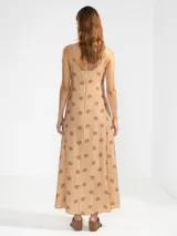 Vestido largo hasta el tobillo de viscosa y poliamida, con estampado de rayas verticales rosas y flores rojas. Tiene breteles finos, escote en V profundo y detalle de flor Polonio en cobre.