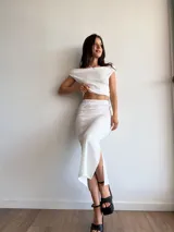 Conjunto blanco de dos piezas de tela bambula elastizada, compuesto por un top con escote recto y una falda midi con cintura elastizada.