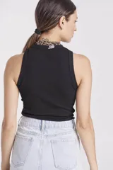 Remera negra sin mangas con cuello alto.