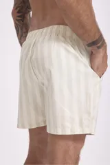 Short de baño color rosa con estampado de hojas y flores en tonos verdes, marrones y blancos.