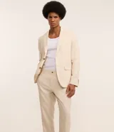 Conjunto de saco y pantalón color beige, confeccionado en lino y viscosa. El saco es de corte clásico con solapas y cierre de dos botones. El pantalón es de corte relajado con cintura con trabillas y bolsillos laterales.