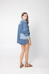 Camisa de jean patchwork con dos tonos de jean, de corte recto, con cuello camisero, cierre frontal con botones y mangas largas.
