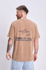 Remera marrón de corte oversize con estampa de estrellas y la frase "Risk It All. Write your own story" en la espalda.