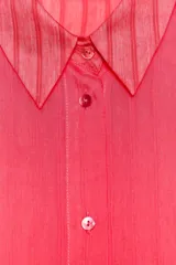Camisa color fucsia con textura de rayas tejidas, de cuello solapa y manga larga. Cierre frontal con botones.