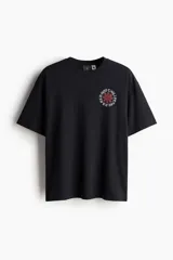 Remera negra de algodón con estampado del logo de Red Hot Chili Peppers en el pecho. Corte holgado y mangas cortas.
