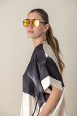 Blusa italiana color natural con estampado de hojas grandes en tonos marrones. Tiene cuello redondo y mangas cortas amplias.