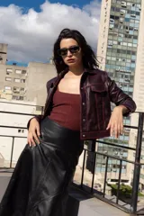 Campera corta de cuero ovino color borgoña, estilo jeanera, con cuello clásico, bolsillos con solapa y cierre frontal con broches metálicos.