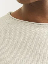 Sweater de punto color beige con cuello redondo y mangas largas.