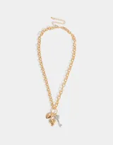 Collar corto dorado con cadena de eslabones gruesos y dijes colgantes: candado con forma de corazón, corazón liso y llave plateados.