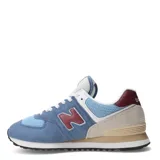 Championes urbanos New Balance modelo 574, color azul claro y azul medio, con detalles en beige, burdeos y blanco. Confeccionados en gamuza y malla, con logo "N" característico en los laterales y entresuela ENCAP.