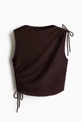 Top marrón sin mangas, de punto texturizado, con escote bote y cordones ajustables en un lateral y en un hombro.