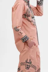Camisa de popelina color rosa con estampado de paisajes italianos en blanco y negro. Tiene cuello clásico, mangas largas con puños abotonados y cierre frontal con botones.