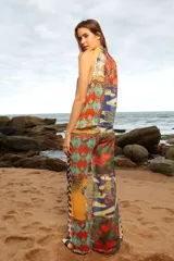 Musculosa con cuello alto y estampado multicolor, confeccionada en tela calada. Se abrocha en la parte posterior del cuello.