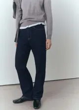 Pantalón de jean azul oscuro de corte recto, tiro medio, con cierre de cremallera y botón.