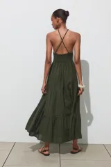 Vestido largo verde con estampado a cuadros, cuello halter con nido de abeja elástico y tirantes trenzados con abalorios.