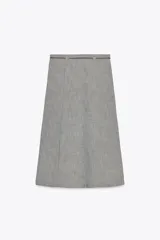 Falda midi de lino color gris con textura. Tiene tiro alto, cinturón fino del mismo tejido y abertura frontal. Cierre lateral con cremallera oculta.