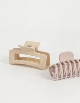 Set de dos broches para el pelo tipo pinza, de plástico mate, uno color beige y otro color lila.