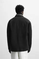 Parka negra de algodón con cuello solapa de cuero sintético, corte recto, acolchada y con cierre frontal de botones.