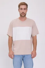Camiseta color beige con bloque blanco horizontal en el pecho con la inscripción 'ORIGINALS' en letras blancas.