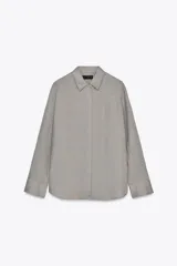 Camisa gris confeccionada en lino 100%, con cuello solapa, manga larga terminada en puño y cierre frontal con botones.