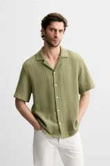 Camisa verde oliva de manga corta con cuello bowling, corte relaxed fit y cierre frontal con botones.