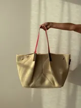 Bolso negro tipo tote de neopreno con bolsillo interno de red, sobre haciendo juego y gancho para sujetarlo.