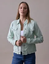 Campera de jean blanca, marca Baccini, con cuello solapa, bolsillos delanteros, abertura central con botones metálicos y terminación desflecada en el ruedo.