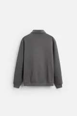Polo manga larga gris con cuello solapa y cierre frontal de botonadura.