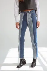 Pantalón jean mom fit de tiro alto, color azul medio con costuras blancas a la vista.
