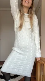 Vestido tejido color blanco con diseño de trenzas, corte midi y mangas largas.