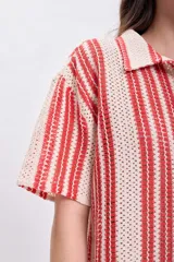 Top de punto crochet color rojo con cuello polo y cierre parcial con botones.