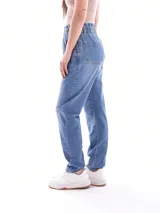 Jean negro de tiro alto con cintura fruncida y cierre de botón. Corte mom fit, ajustado en la cintura y más holgado en la cadera y muslos, con puños doblados en el tobillo.