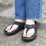 Ojota de recuperación Hoka Ora Recovery Flip, color negro, con tiras anchas y suela gruesa con relieve.