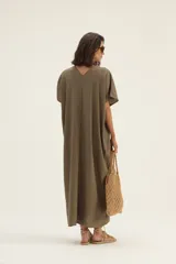 Vestido largo color visón, de lino, corte amplio, mangas cortas tipo murciélago y escote en V.