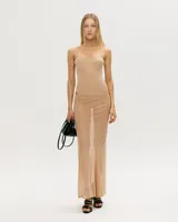 Conjunto de dos piezas color beige, compuesto por un corset con ballenas y tirantes finos, y una falda larga de corte recto con abertura frontal.