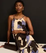 Vestido evasê largo midi de frente única, confeccionado en viscosa, con estampado de hojas en tonos beige, negro y celeste.