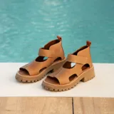 Sandalias de cuero color marrón claro, con puntera descubierta, tira ancha sobre el empeine, talonera cerrada y suela track.