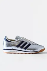Championes Adidas SL 72 plateados con detalles en azul marino y suela de goma marrón.