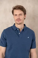 Chomba azul marino de piqué con cuello clásico, tapeta de dos botones y logo de pájaro bordado en color rosa en el pecho.