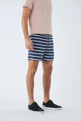 Short de baño azul con estampado de hojas y flores en blanco. Tiene cintura elástica con cordón ajustable, dos bolsillos laterales y uno trasero.