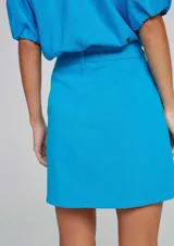 Pollera corta celeste con bolsillos, de cintura alta y diseño moderno.