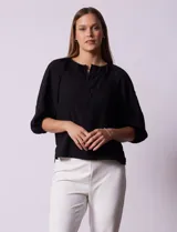 Blusa blanca de gasa marca Sioni, con cuello a la base y escote en V con botones.
