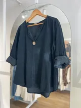 Blusa negra de pana fina con cuello en V y mangas 3/4 con puños arremangados.