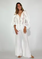 Pantalón de jean blanco de corte ancho con aberturas laterales en el ruedo y costuras a contratono.