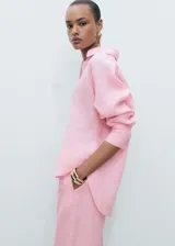 Camisa rosa de lino con cuello camisero, manga larga con puños abotonados, diseño oversize y cierre delantero con botones.