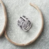 Anillo plateado de triple alianza con números romanos y circonitas.