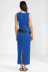 Top sin mangas color azul eléctrico, con detalle de abertura lateral en la cintura y logo metálico en la parte posterior.